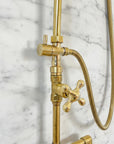 Brass shower system mounted on a gray marble wall