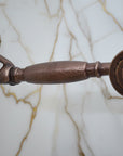Vintage-style copper shower head and hose against a light blue background