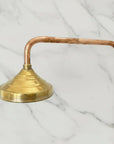 Brass shower head with copper hose on a marble background