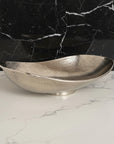 Silver hammered bowl on a white surface with a white background