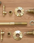 Collection of brass plumbing fixtures and parts on a wooden surface