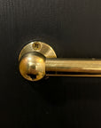 brass pot rail on a black wall