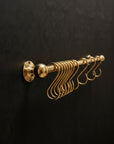 Gold hook rack on a black textured wall