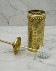 Decorative gold cylindrical container with a brush on a marble surface