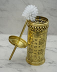 Decorative gold holder with a white brush on a marble surface