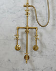 Brass shower system mounted on a gray marble wall