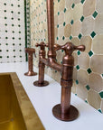 Copper faucet in a bathroom with tiled wall
