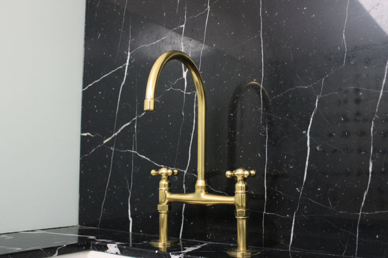 Gold faucet on a black marble wall