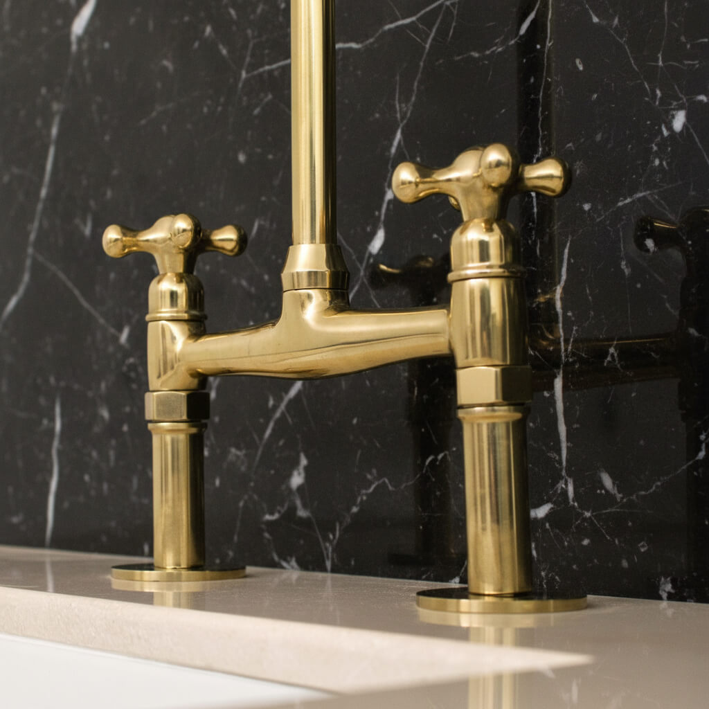 brass bridge faucet on a black marble background