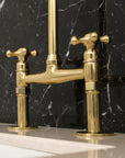 brass bridge faucet on a black marble background