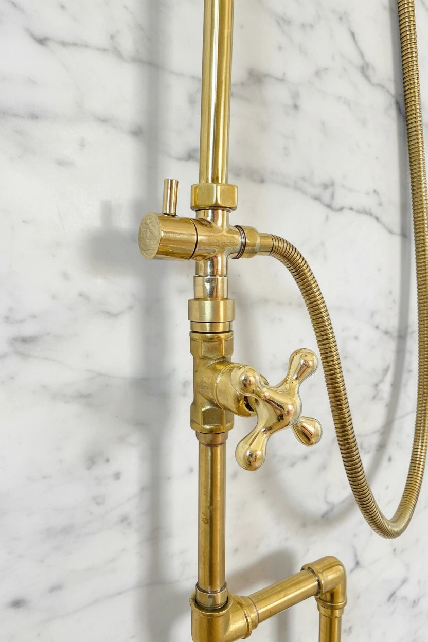 Brass shower system mounted on a gray marble wall