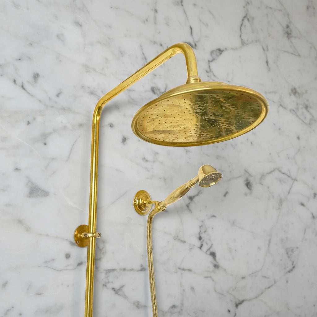 Brass shower system mounted on a gray marble wall