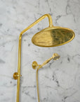 Brass shower system mounted on a gray marble wall