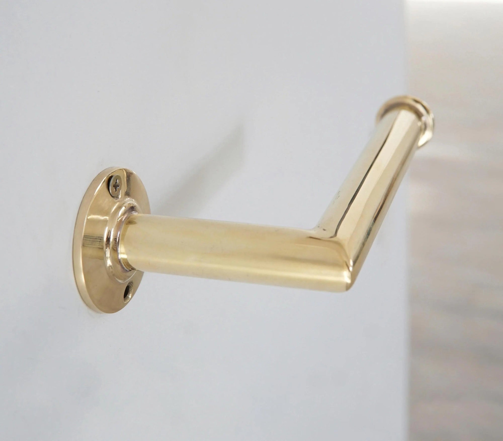Brass towel holder on a white wall