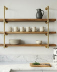 Modern kitchen with brass shelves, coffee maker, and kitchenware.