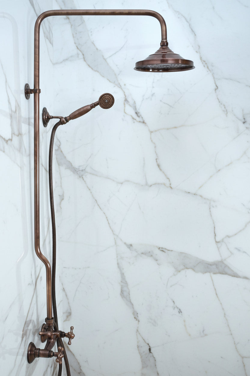 Vintage-style bronze shower head and control panel on a white background