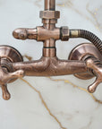 Bronze faucet with hose on a light blue background