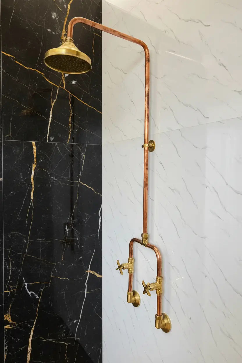 Handmade Copper Outdoor Shower and faucet system on a black and white marble wall.