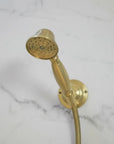 Gold shower head and hose on a marble background