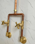 Brass and copper plumbing fixtures on a marble wall.