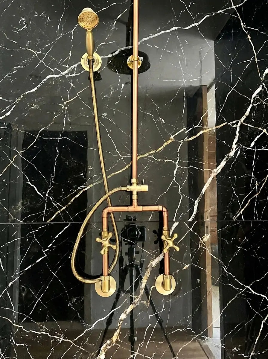 Copper shower head and fixtures on a marble wall