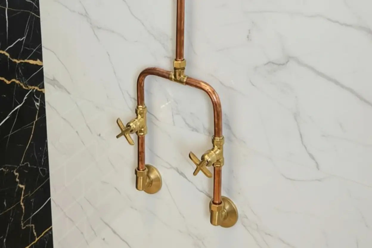 Brass and copper faucet on a marble wall