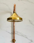 Brass shower head on a marble wall