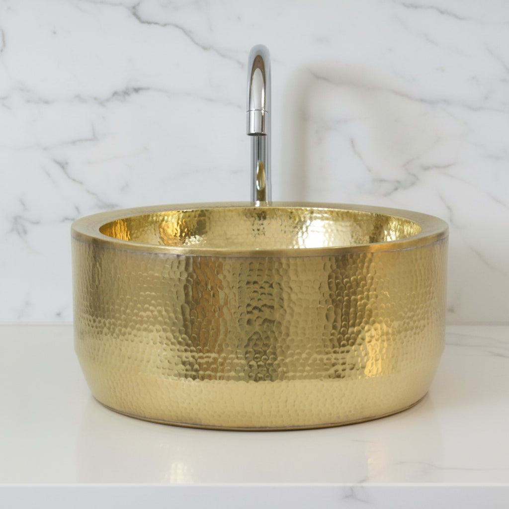Gold metallic bowl on a white surface with a light gray tiled background