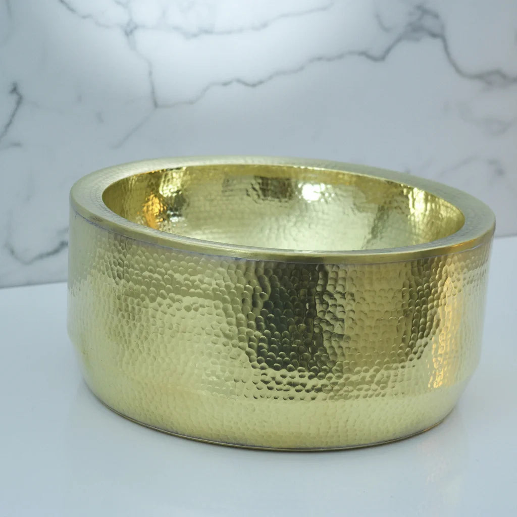 Handmade Hammered Brass Bathroom Sink with a textured surface on a marble background
