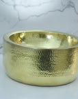 Handmade Hammered Brass Bathroom Sink with a textured surface on a marble background