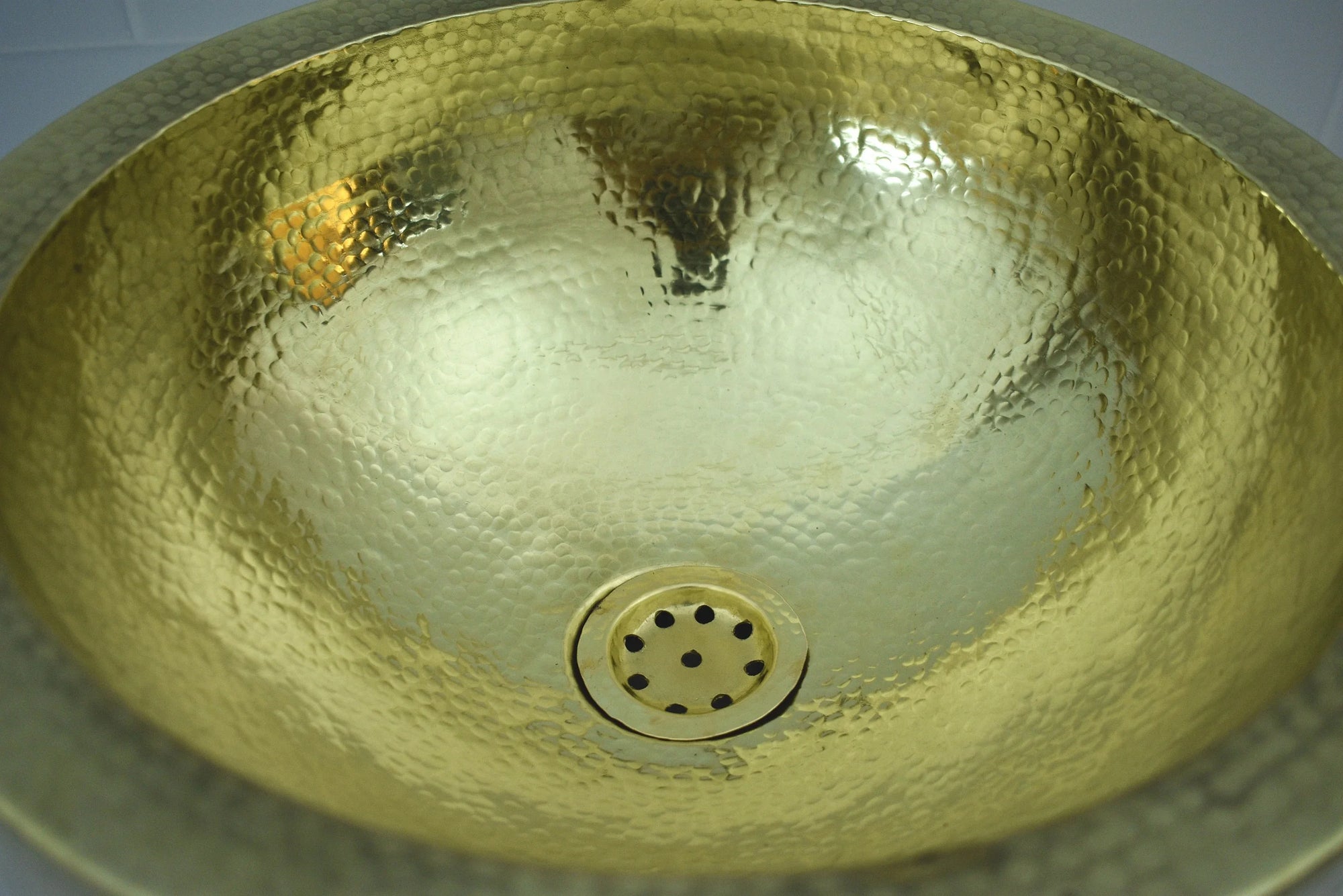 Handmade Hammered Brass Bathroom Sink with a textured surface and central drain.