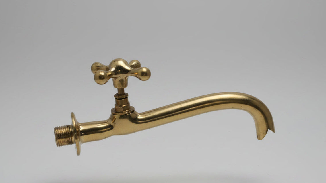 Brass faucet on a gray background