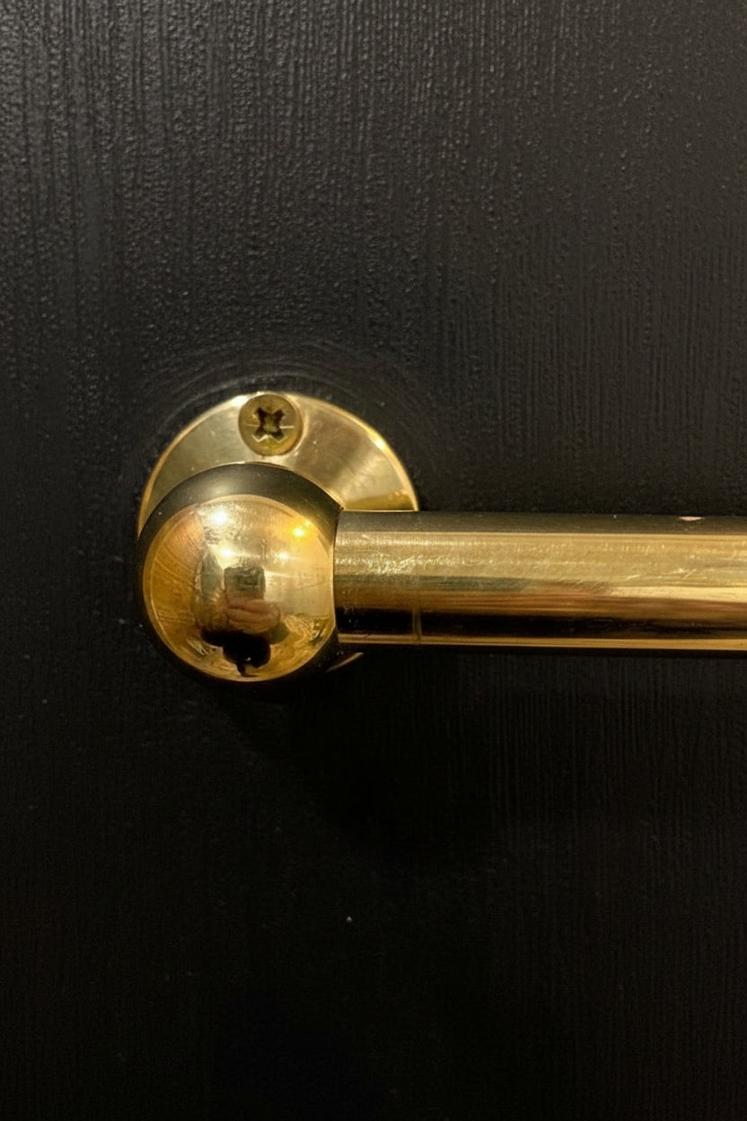 brass pot rail  on a black wall