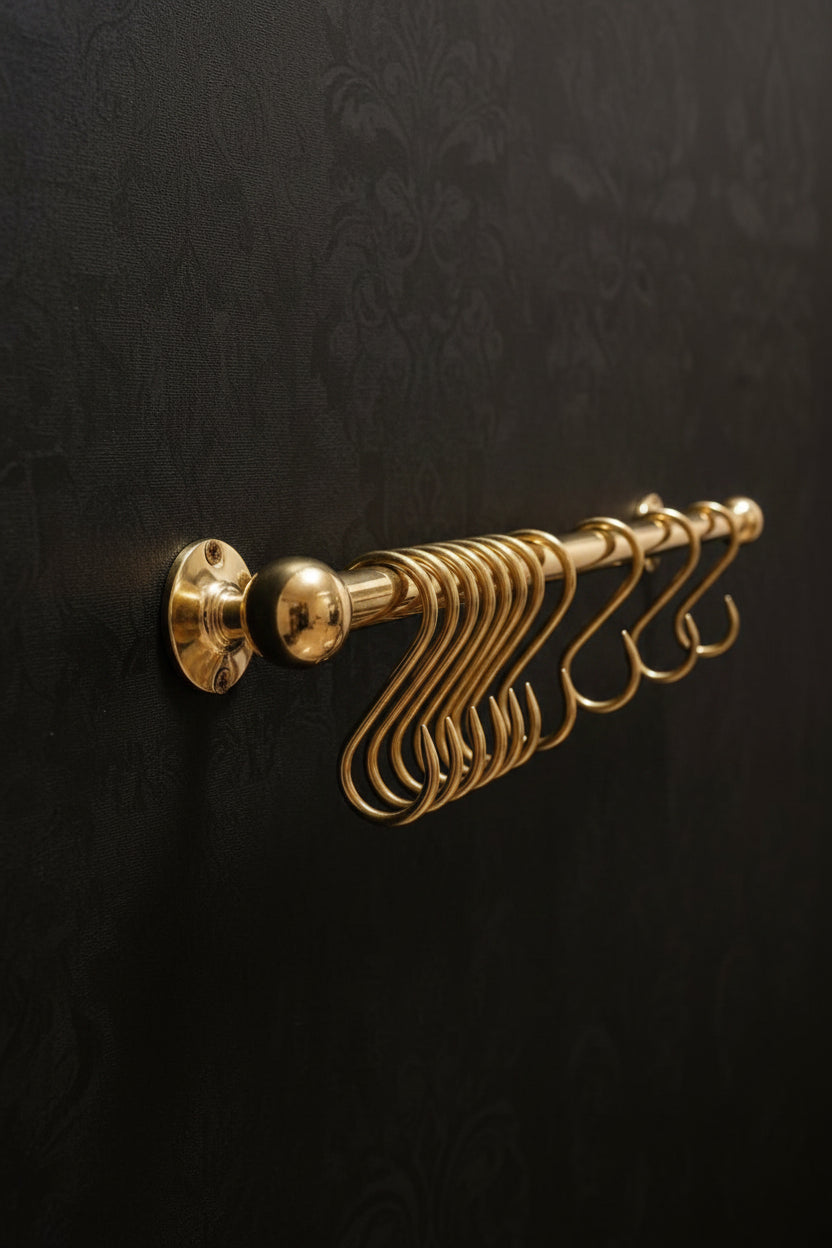 Gold hook rack on a black textured wall