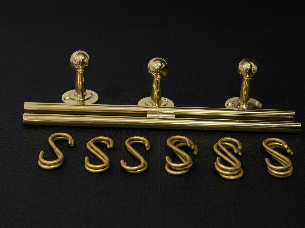 Set of gold-colored metal letter components on a black background
