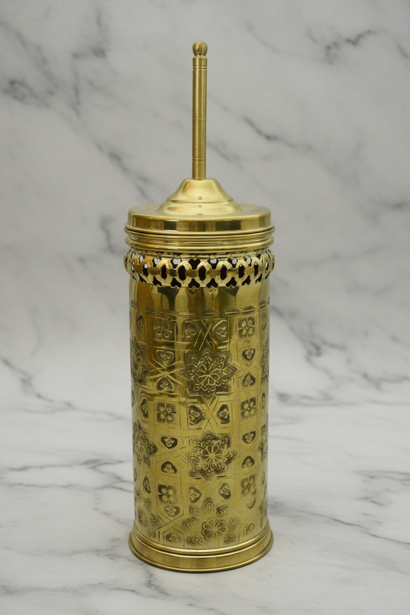 Decorative gold container with intricate patterns on a marble surface