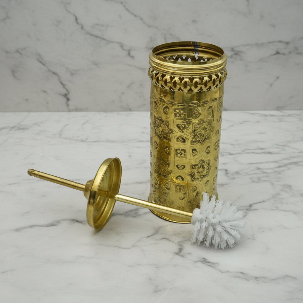 Decorative gold cylindrical container with a brush on a marble surface