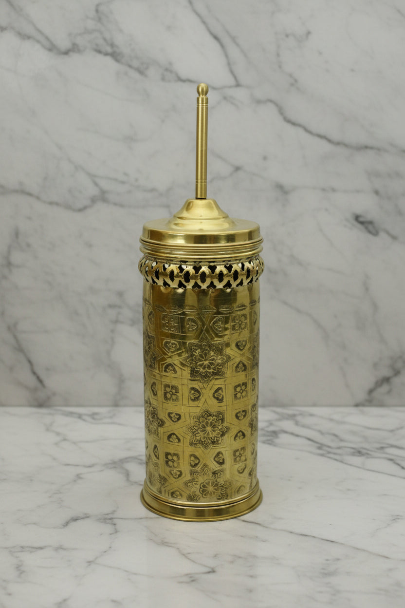 Decorative gold container with intricate patterns on a marble surface