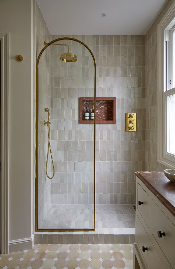 Modern bathroom with tiled shower area and wooden shelves.