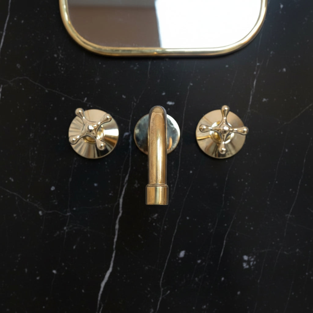 Brass bathroom faucet on a marble wall