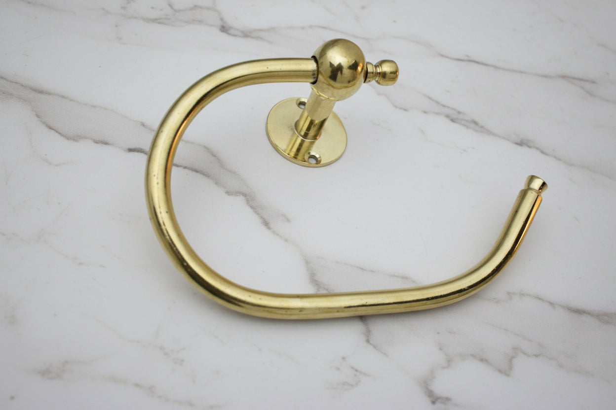 Gold towel ring on a gray textured surface