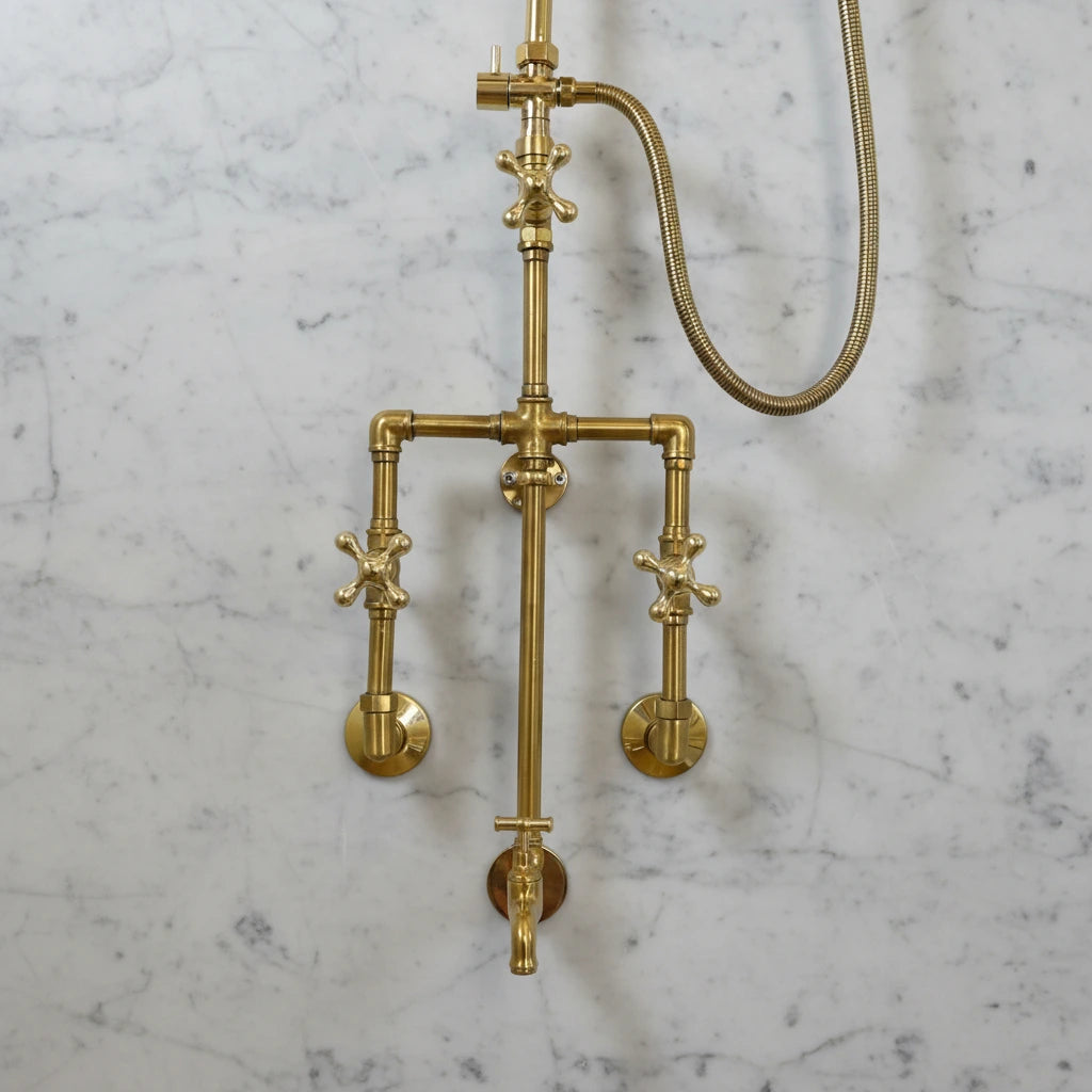 Brass shower system mounted on a gray marble wall