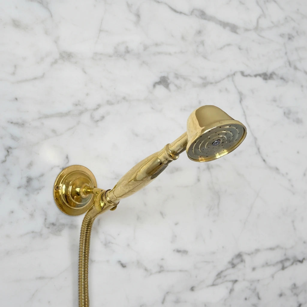 Brass shower system mounted on a gray marble wall