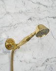 Brass shower system mounted on a gray marble wall