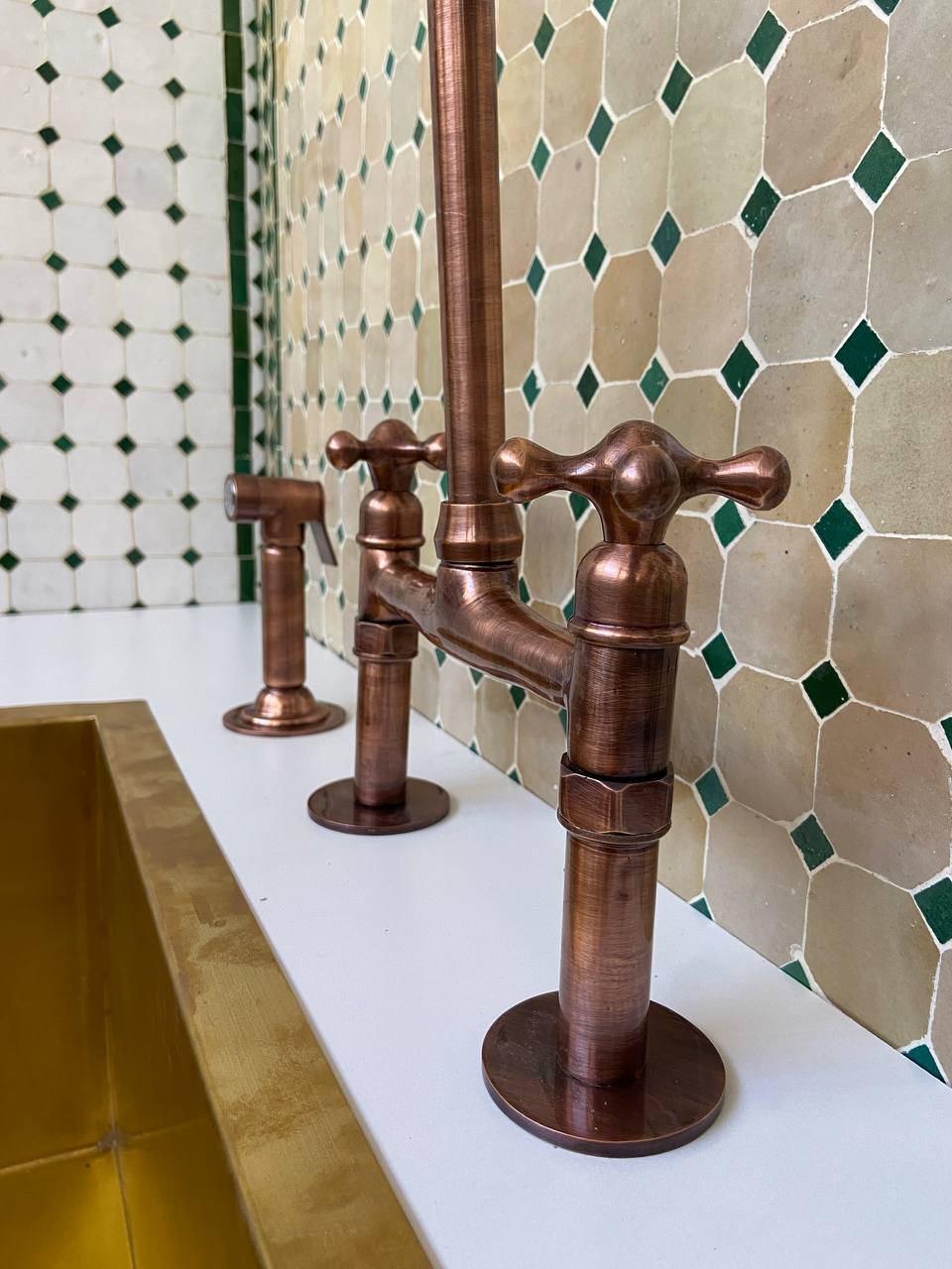 Copper faucet in a bathroom with tiled wall